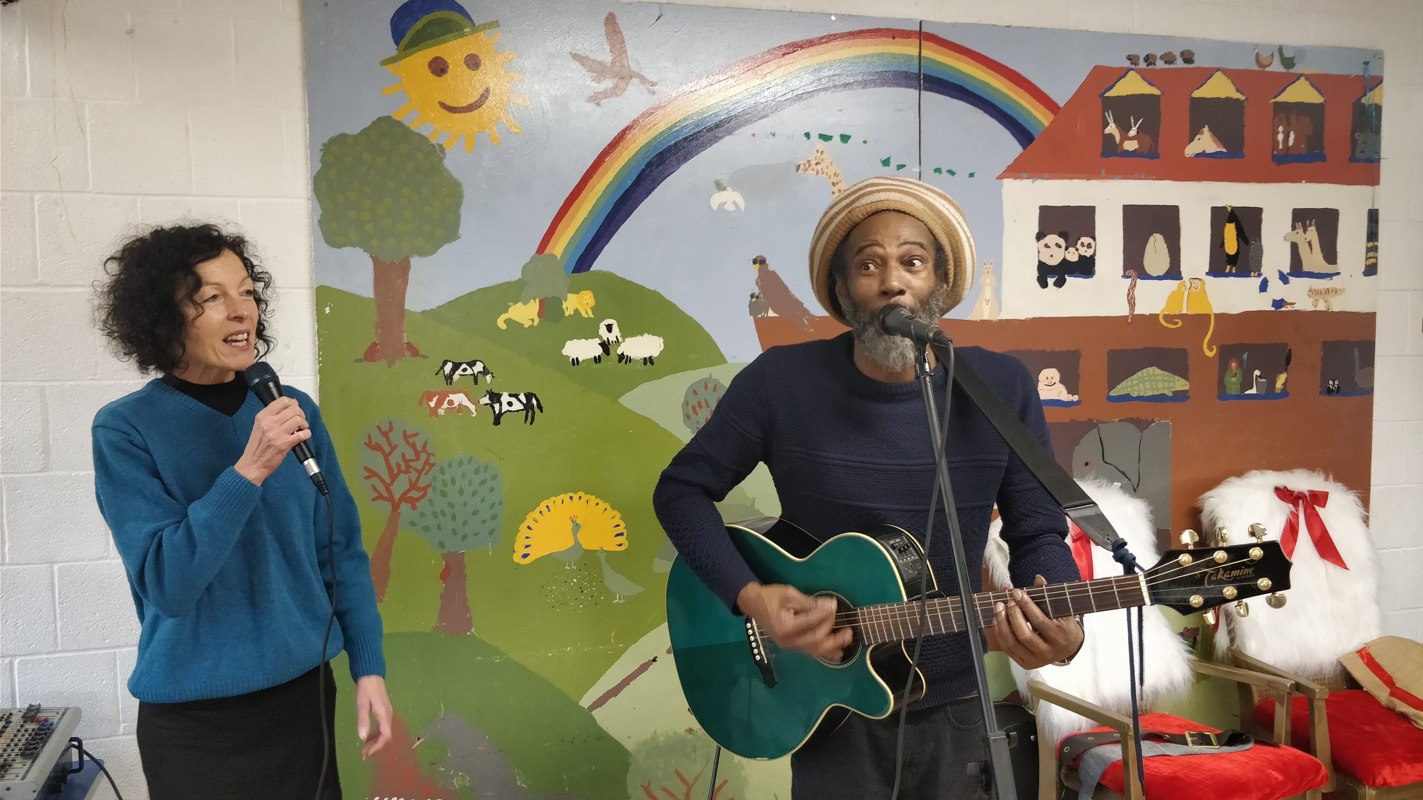 Musicians playing in front of a mural